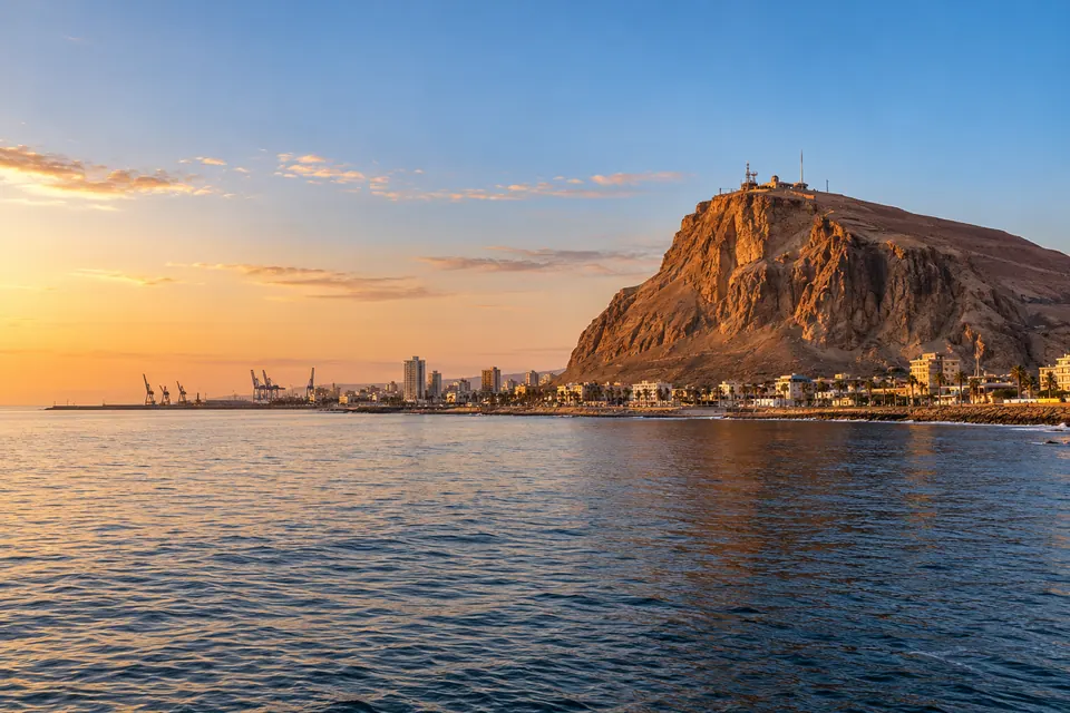 Ilustración del Morro de Arica y la costa de la ciudad al atardecer